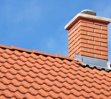 Photo of a chimney with rust colored shingles